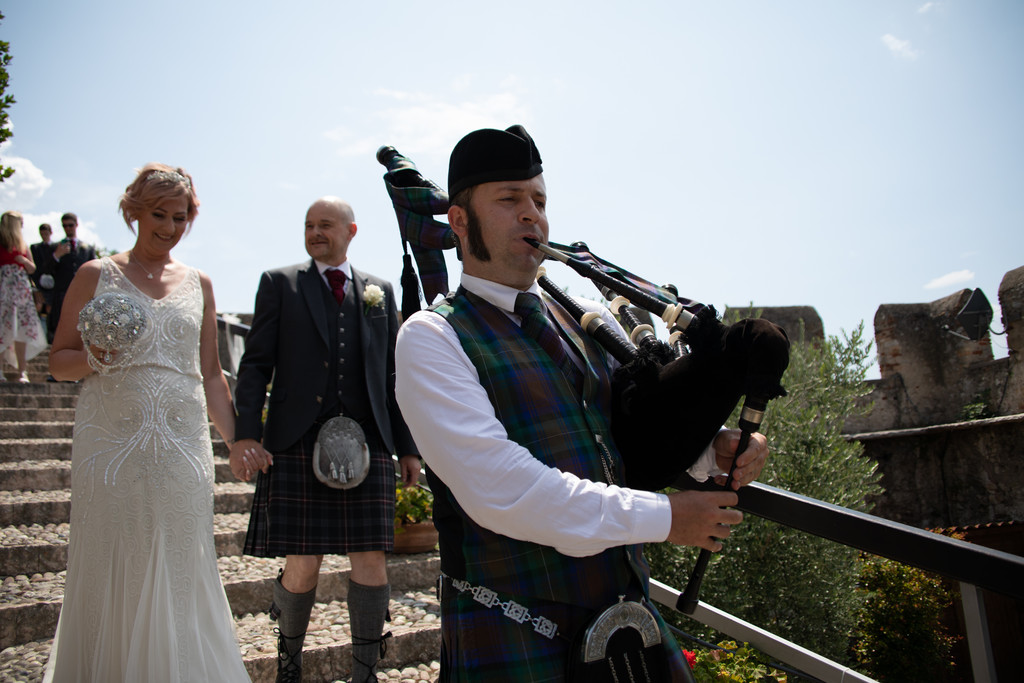 Happy married couple and piper in Malcesine castle