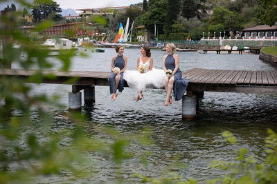Beautiful Bride and bridesmaids on pier in Lake Garda