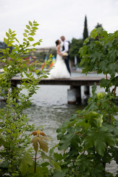 Lake Garda through the trees bride and groom
