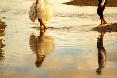 Reflections of bride & groom in the sea