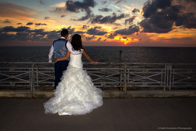 Bride & Groom watching the sun set over the sea
