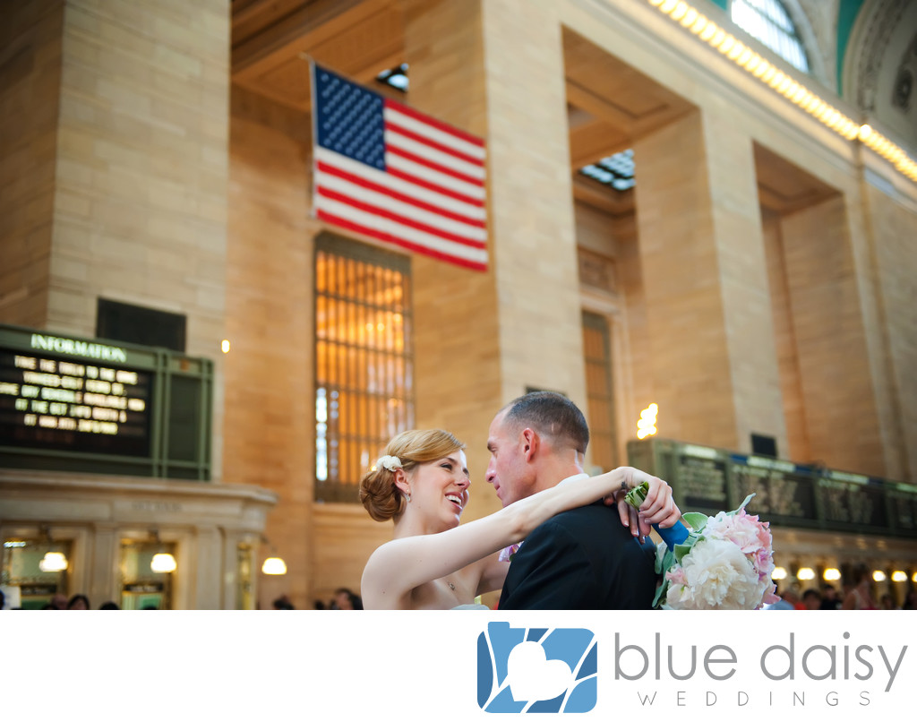 The wedding couple embrace under American flag
