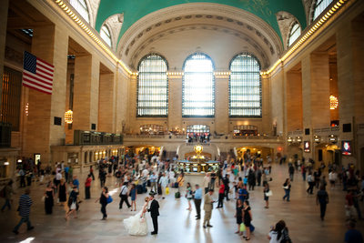 Wedding couple kissing in the crowd in Grand Central