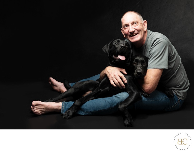 Heartwarming Portrait of Man with Black Labradors