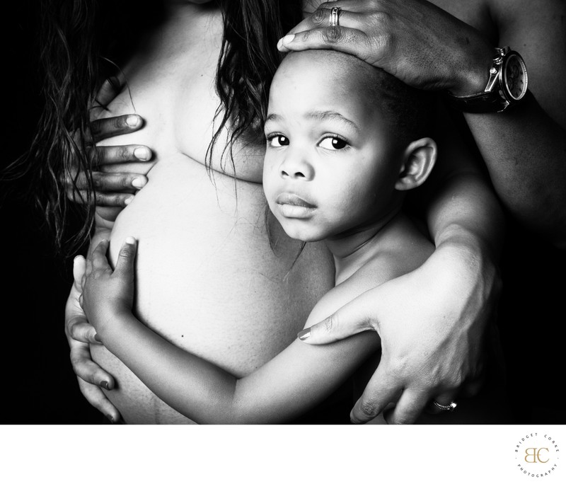 Tender Moment: Child Embraced in Maternity Portrait