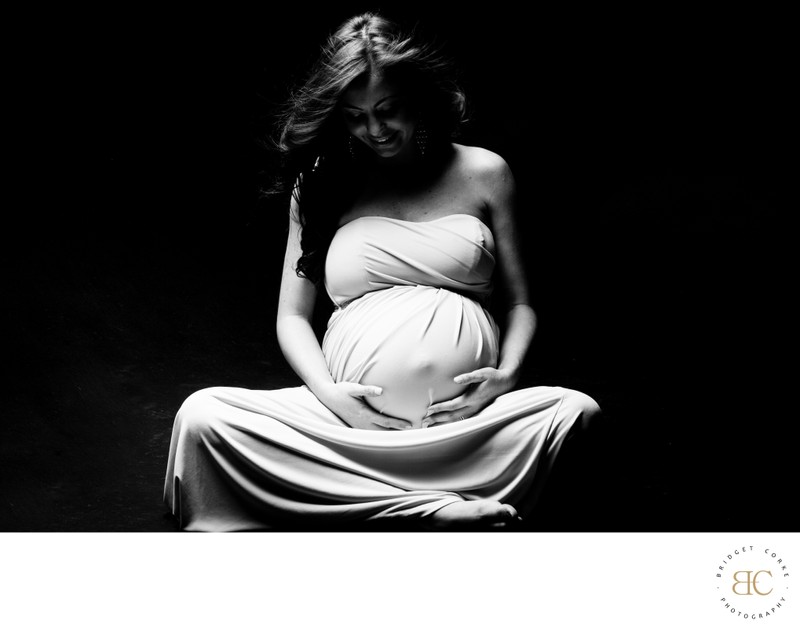 Elegant Expectant Mother Cradling Her Belly in Gown