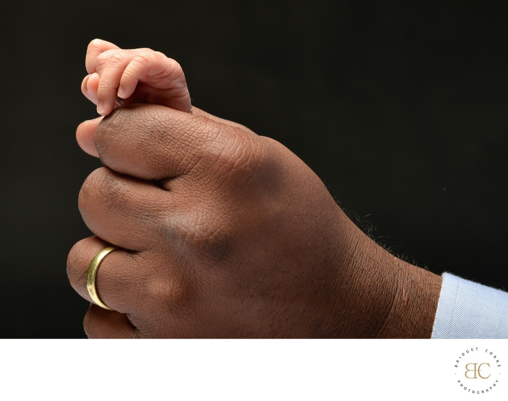 Newborn Fingers Popping Out of Dad's Hand