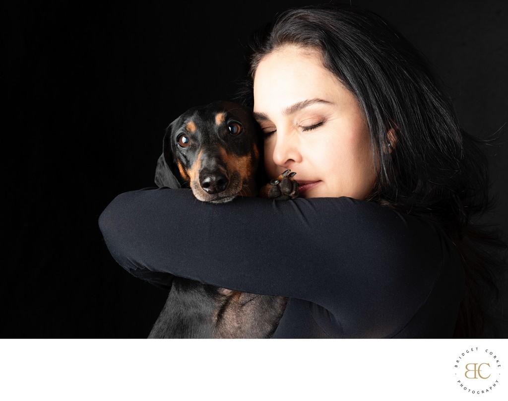 Black Dachshund Being Hugged By Lady