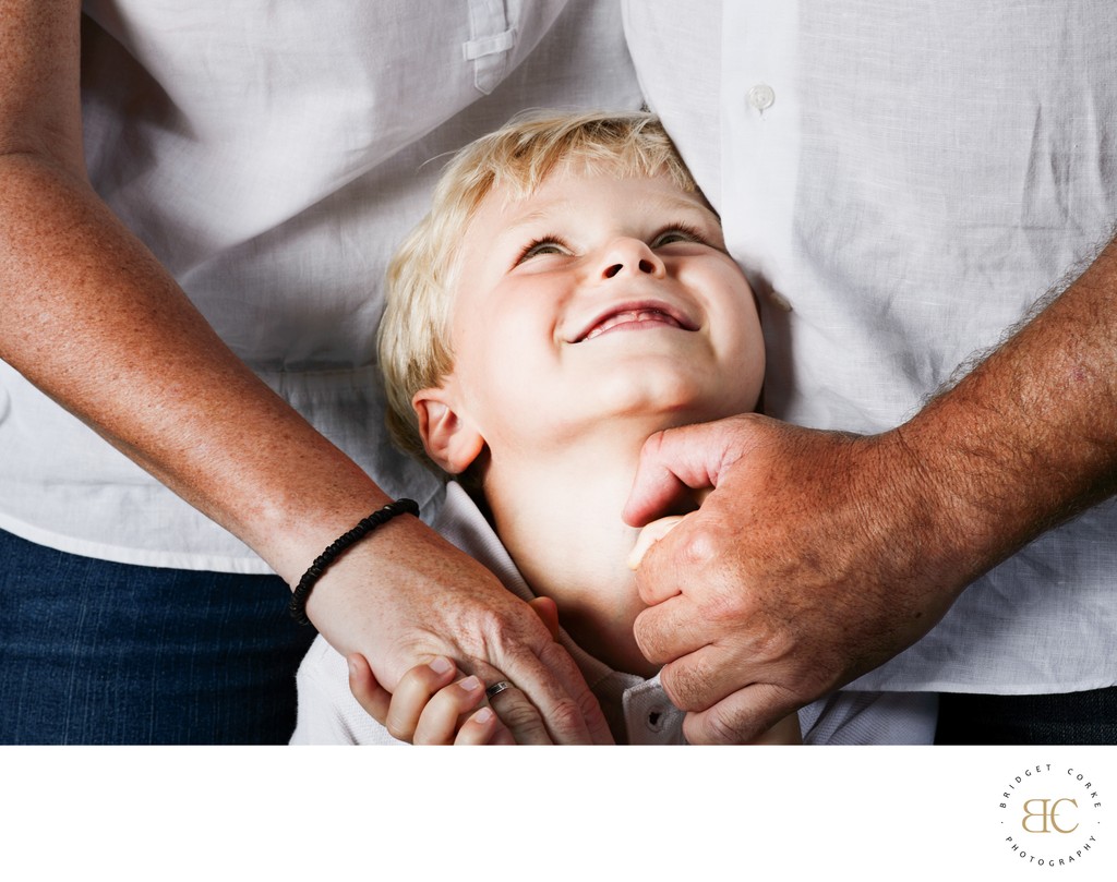 Parents Loving Embrace with Child Looking Up