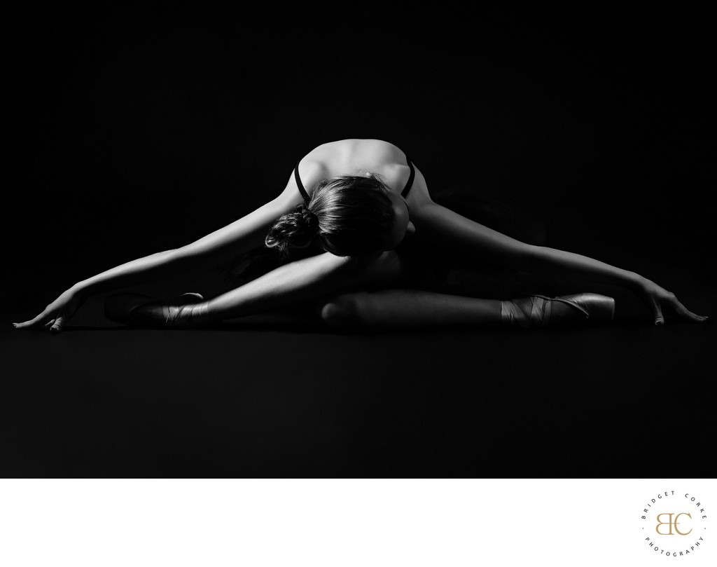 Award-Winning Ballerina Stretching Under Dramatic Light