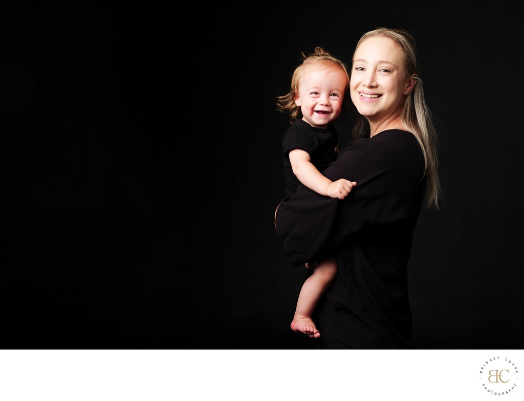Smiling Mum in Black Holding Laughing Son