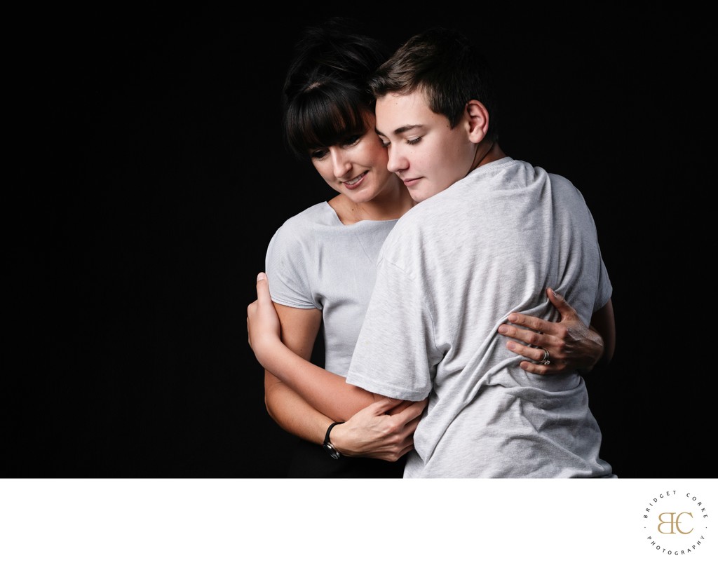 Mother Embracing Her Teenage Son in Studio