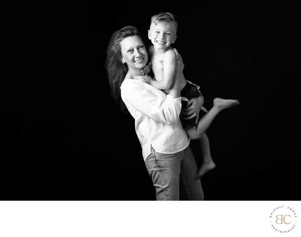 Mother Holding Her Barefoot, Smiling Son