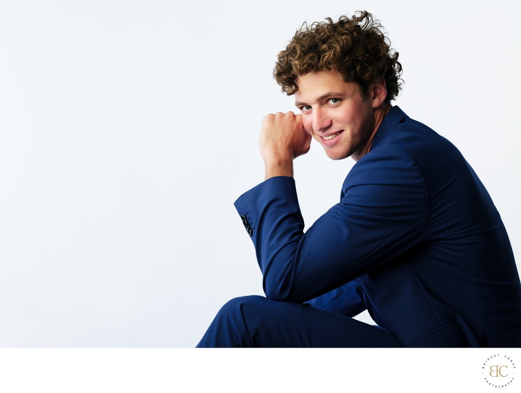 Seated Male Model in Blue Suit Smiling