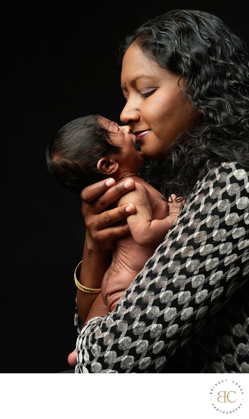 Crying Newborn With Mother Kissing