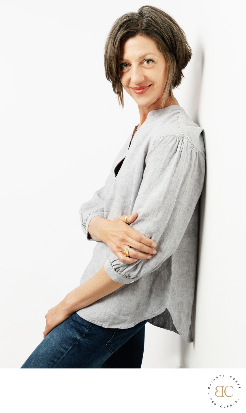 Relaxed Portrait of a Woman Leaning Against a Wall