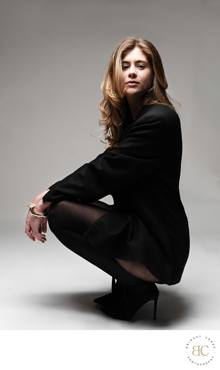 Squatting Fashion Portrait in Black Blazer Dress