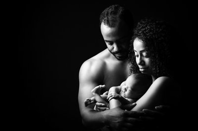 Newborn Held By Shirtless Parents