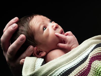 Newborn Wrapped In Knitted Blanket