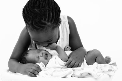 Sister Staring At Newborn Brother