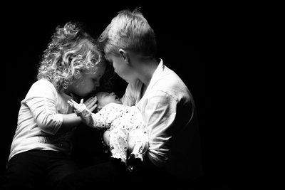 Loving Siblings Holding Newborn Brother