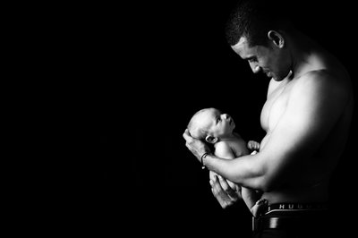 Shirtless Father Holding Newborn