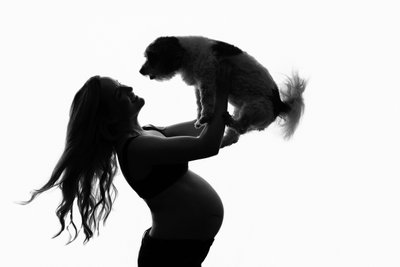 Silhouette of Pregnant Woman Lifting Dog