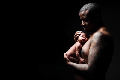 Father’s Strength: Cradling Newborn in Love