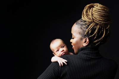 Mother’s Elegance: Newborn Over Her Shoulder