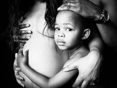 Tender Moment: Child Embraced in Maternity Portrait