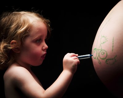 Young Child Creating Art on Mother's Baby Bump