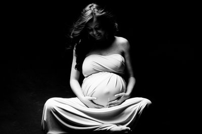 Elegant Expectant Mother Cradling Her Belly in Gown