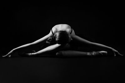 Award-Winning Ballerina Stretching Under Dramatic Light