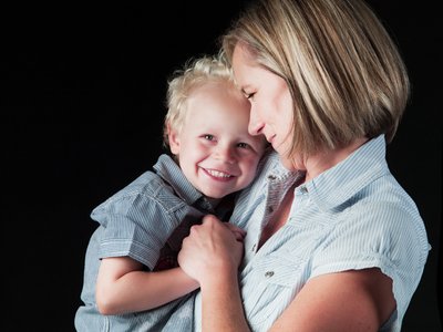 Blonde Son Wrapped in Mother’s Loving Arms