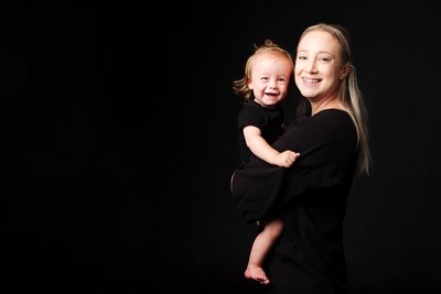 Smiling Mum in Black Holding Laughing Son
