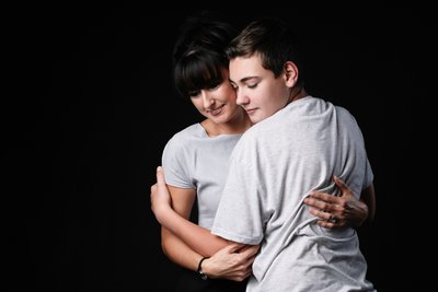 Mother Embracing Her Teenage Son in Studio