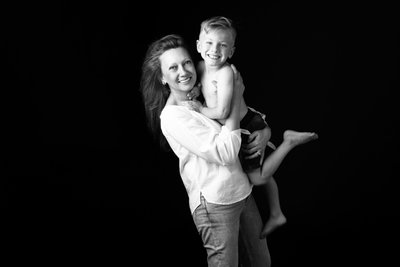 Mother Holding Her Barefoot, Smiling Son