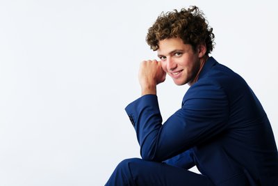 Seated Male Model in Blue Suit Smiling
