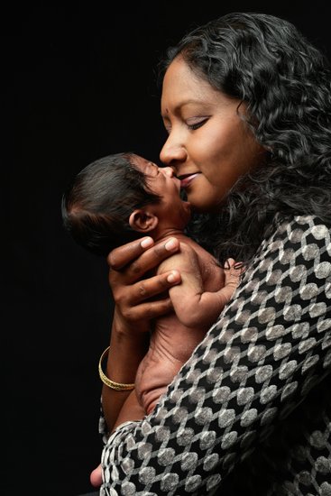 Crying Newborn With Mother Kissing