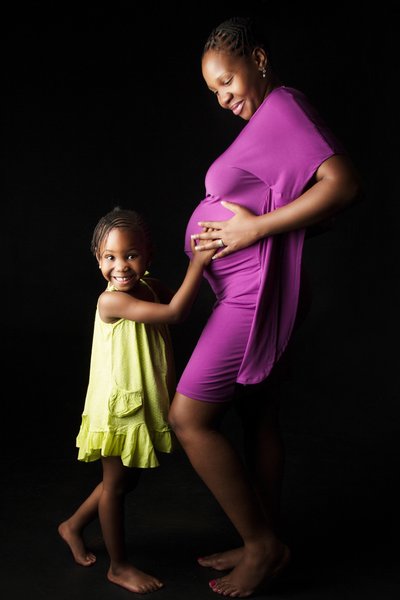 Joyful Daughter Holding Mother's Pregnant Belly