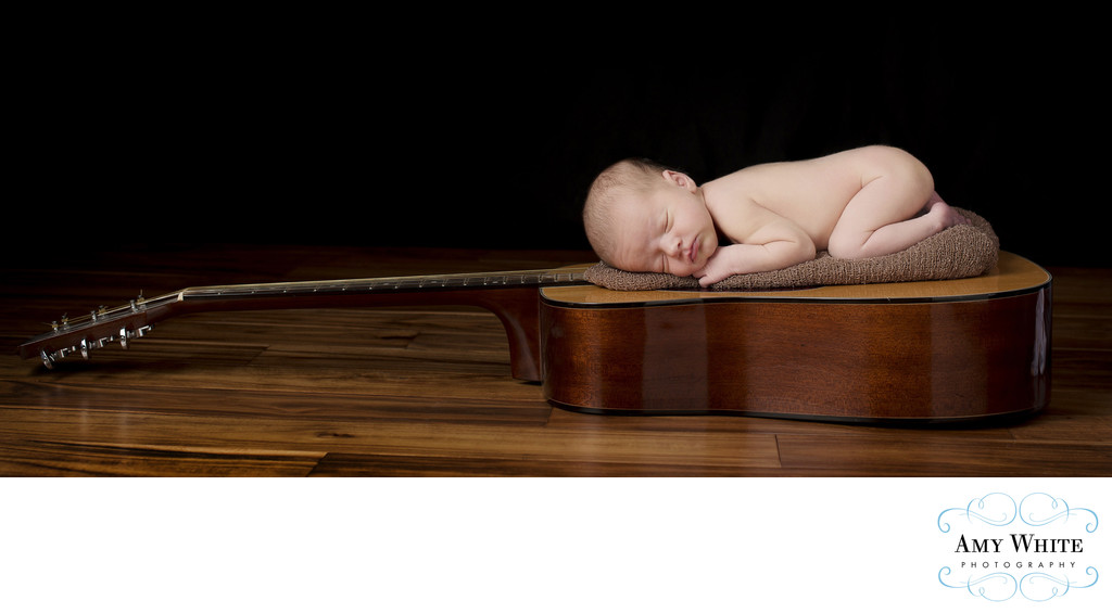 Newborn on dad's guitar/Cedar Rapids baby photographer