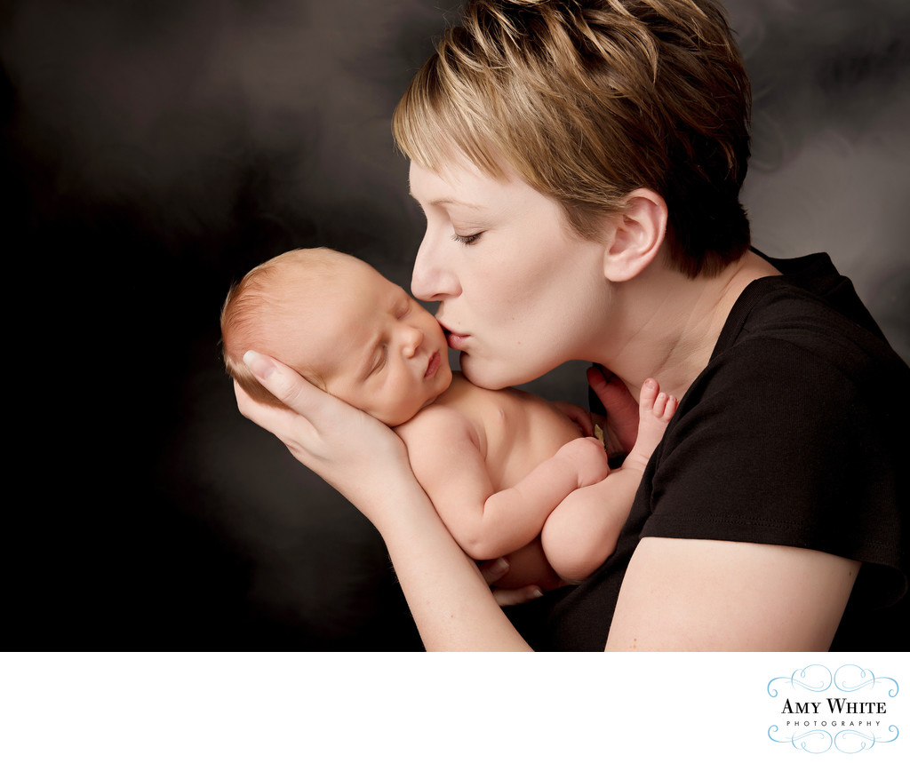 Mom kissing newborn, Studio photo shoots in Cedar Rapids, Iowa
