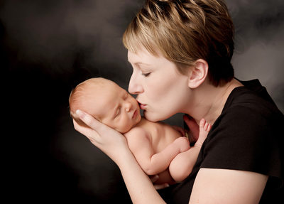 Mom kissing newborn, Studio photo shoots in Cedar Rapids, Iowa