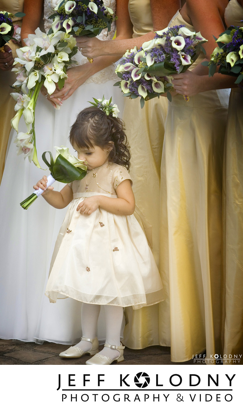 Flower girl smelling flowers at a South Florida wedding