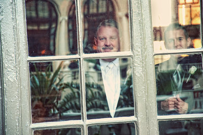 Brides father watches through a Breakers window.