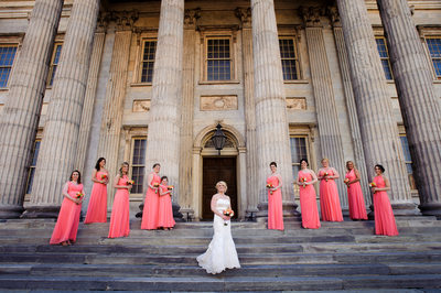 Coral bridesmaids, ionic columns and a lovely bride. 