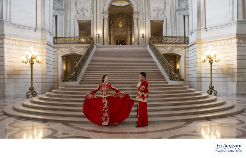 Asian Couple with red wedding gowns celebrating at the Grand Staircase