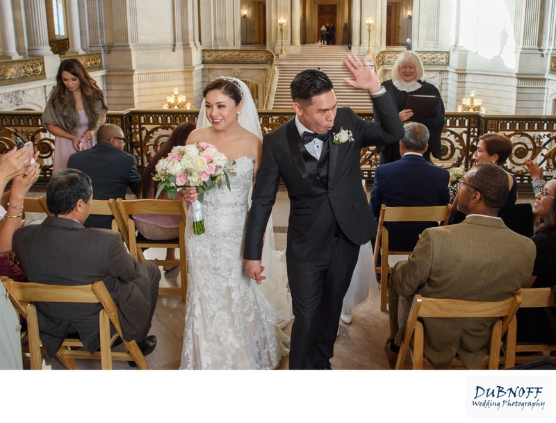 Bride and groom walk down the aisle after completing their Mayors Balcony wedding