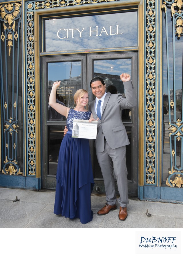 Newlyweds showing their Marriage License outside of SF City Hall