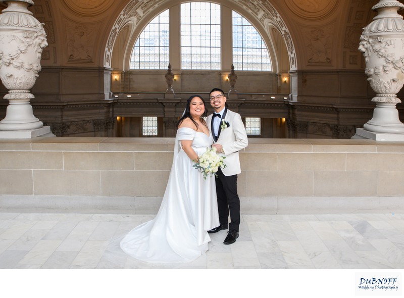 Newlyweds smiling on the 4th floor of SF City Hall